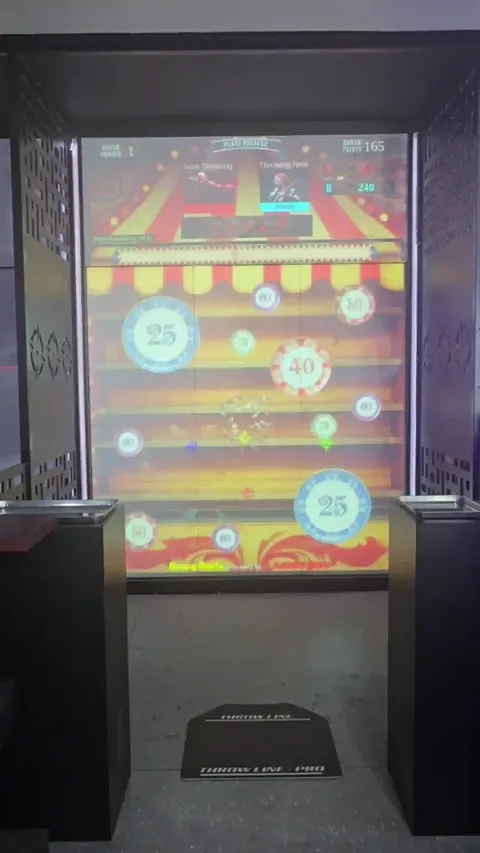 Inside a Krazy Darts booth, mid-game