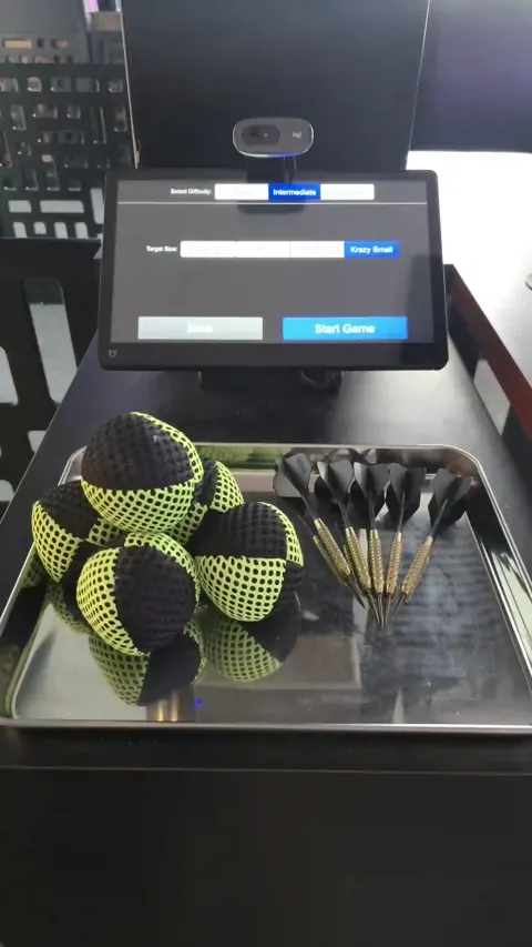 Steel-tipped darts and soft juggling balls in the throw tray